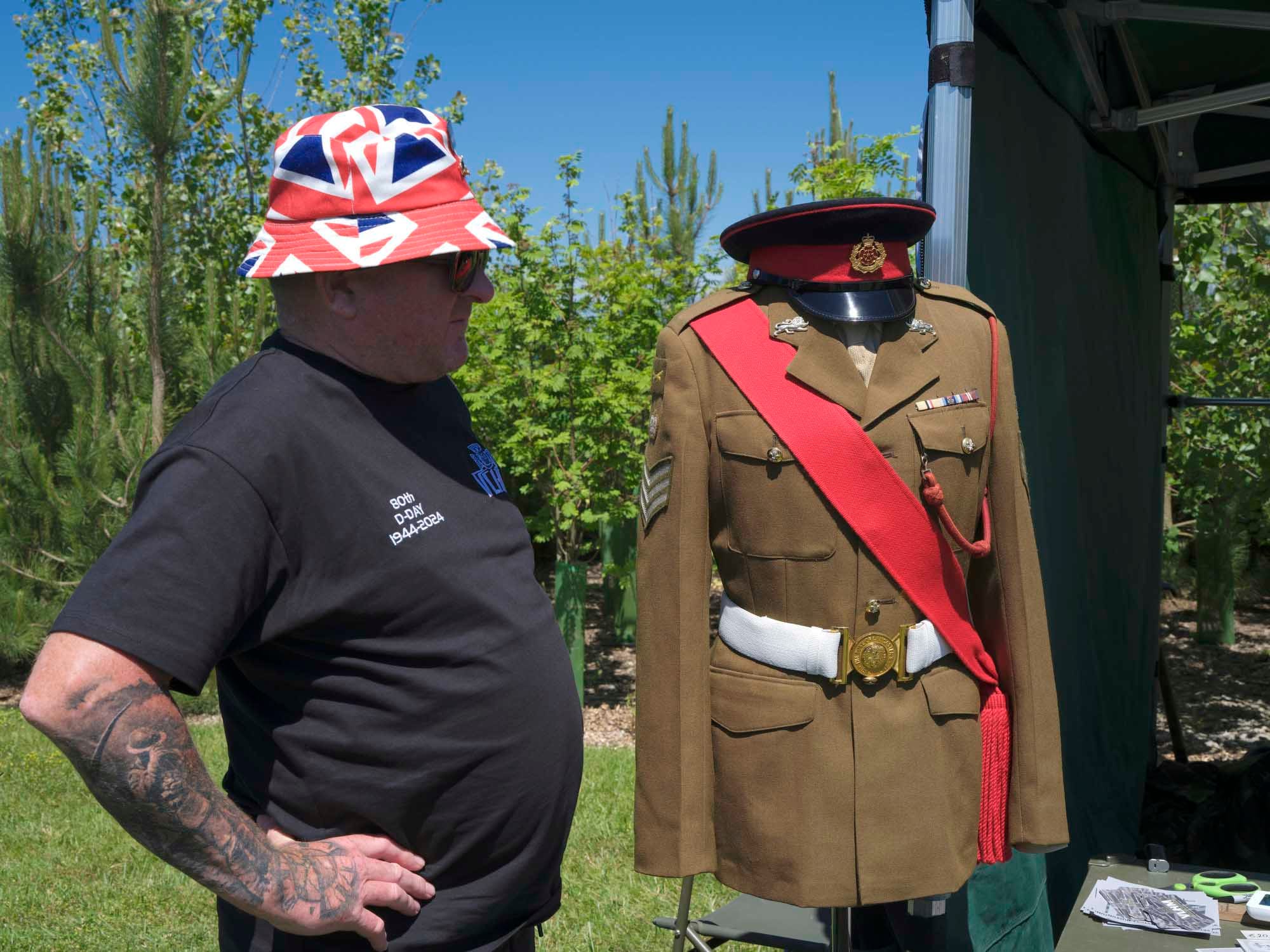 英軍紀念墓園，遊客站在一套二戰軍服旁邊。攝影：Vincent Yu