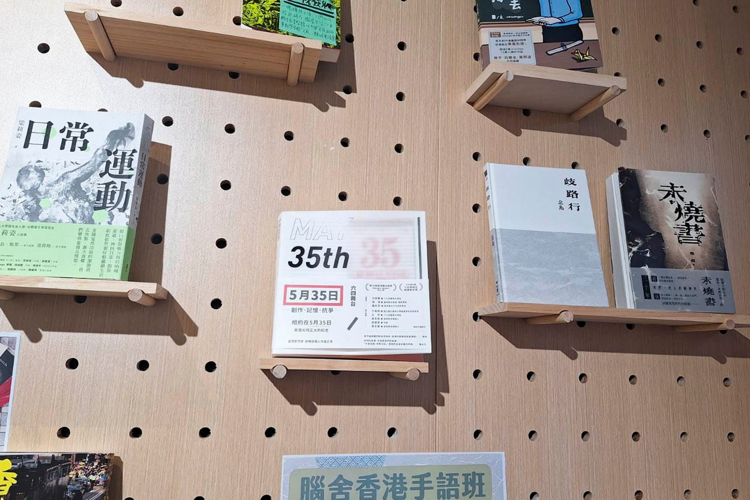 六四前夕，有警察到前民主派区议员黄文萱开设的猎人书店，登记出入人士身份证。2024年6月4日，书店门前红色的“35/5”字样依旧。书墙上，香港剧作家庄梅岩创作的舞台剧《5月35日》放在置中位置。