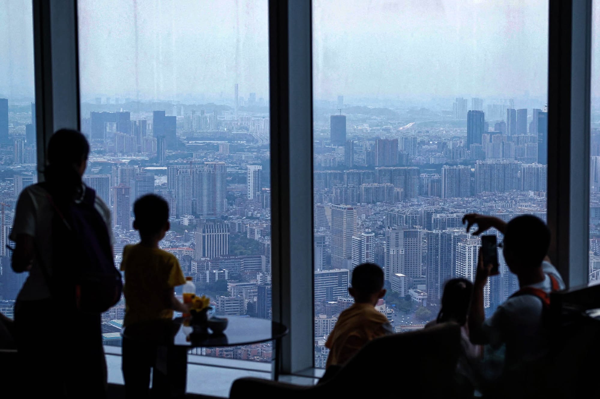 2024年4月4日,廣州市的一家飯店,人們欣賞城市景觀。攝:Tingshu Wang/Reuters/達志影像