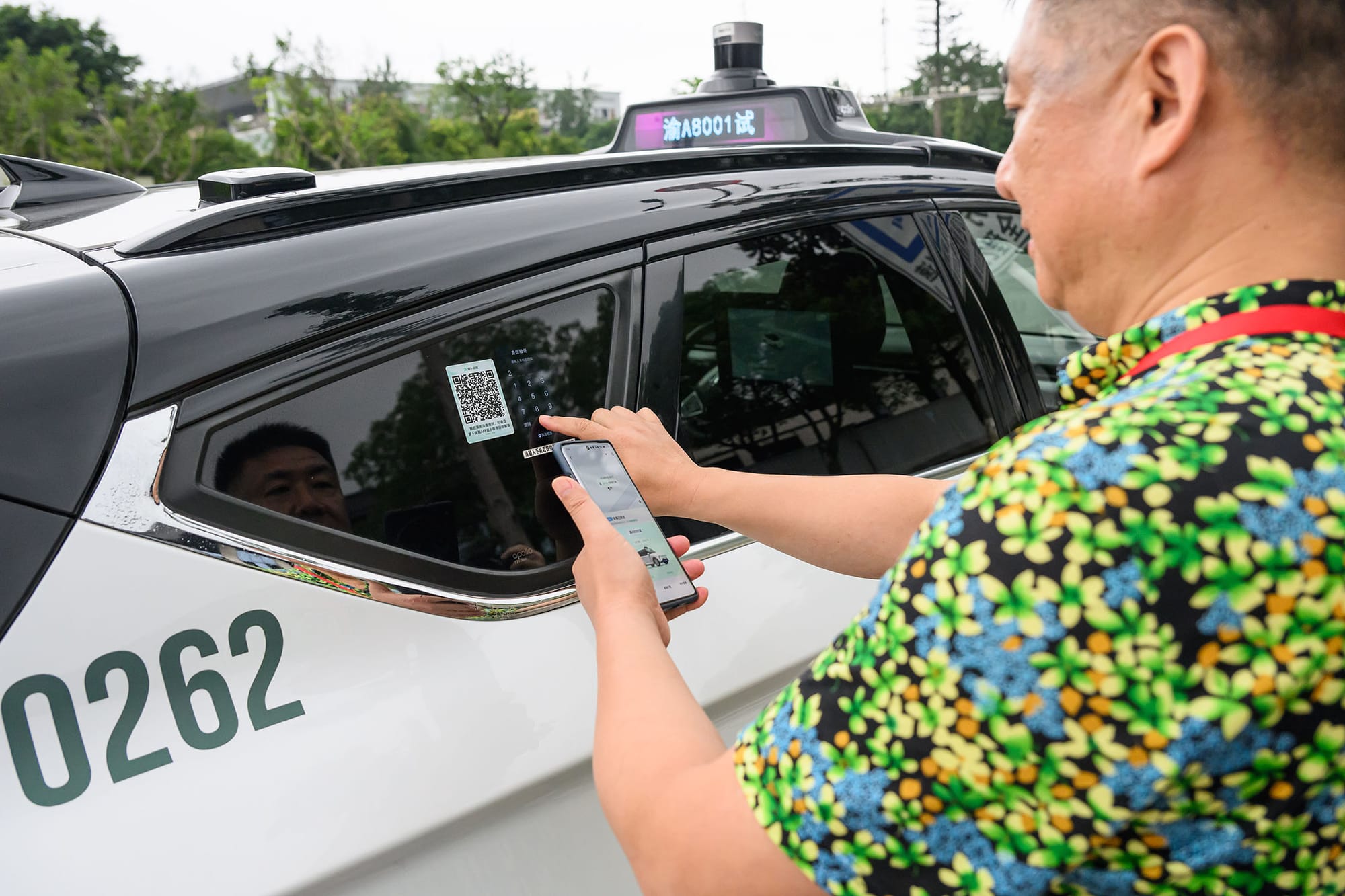 2024年7月10日，中國重慶，乘客掃描二維碼乘坐無人自動駕駛出租車平台「蘿蔔快跑」。攝：He Penglei/China News Service/VCG via Getty Images