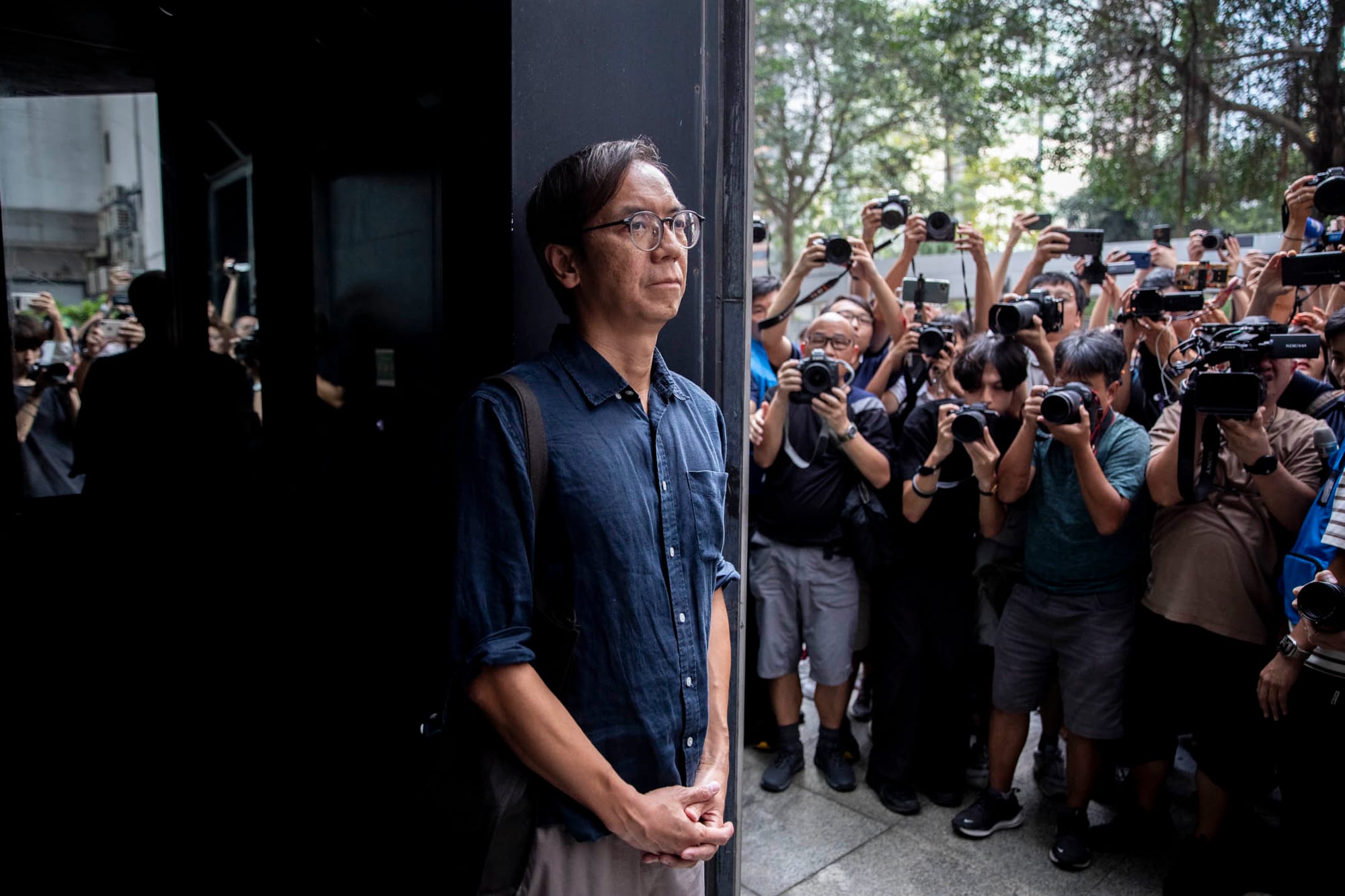 2024年8月29日,“立场新闻”母公司、前总编辑钟沛权、时任署任总编辑林绍桐被控串谋发布煽动刊物案在区域法院裁决,其中钟沛权离庭时被大批传媒包围拍摄。摄:林振东/端传媒