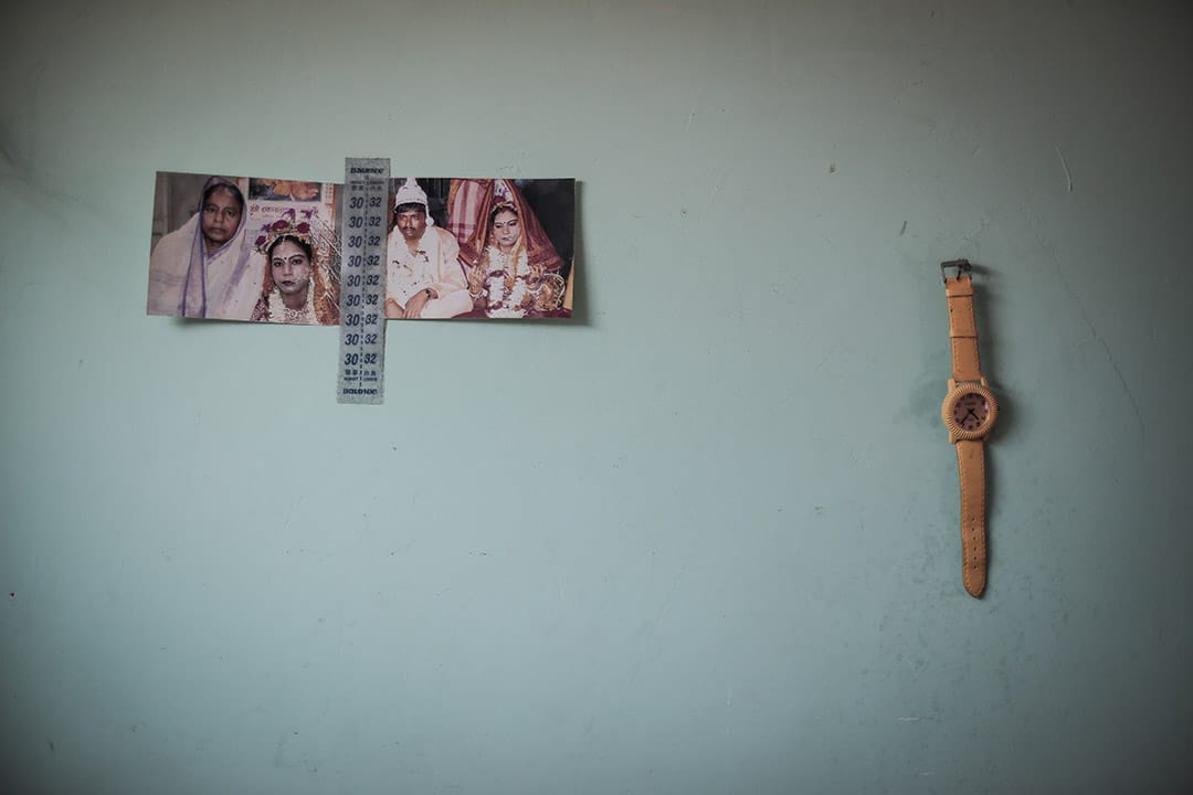 2013年，一位寻求庇护者家中墙上的布置，包括以前的结婚照，以及一只手表。摄: Billy H.C. Kwok/ 端传媒
