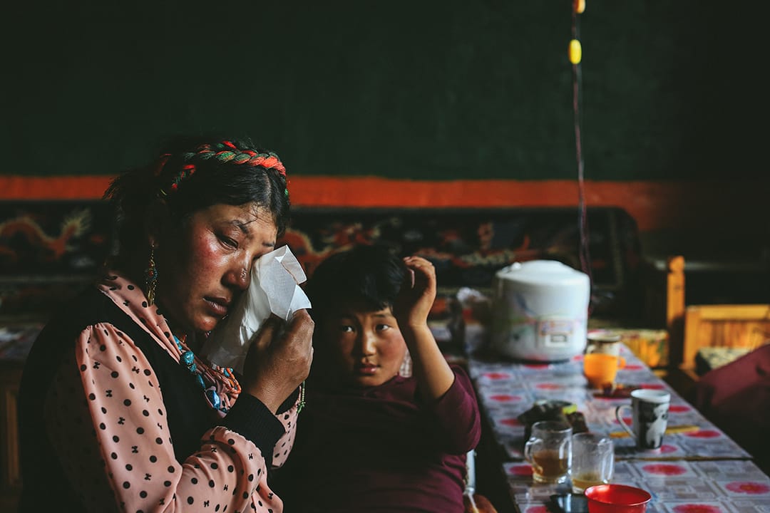 索加乡移民村村民想起在地震中失去的亲人不禁落泪。摄 : 王嘉豪/端传媒