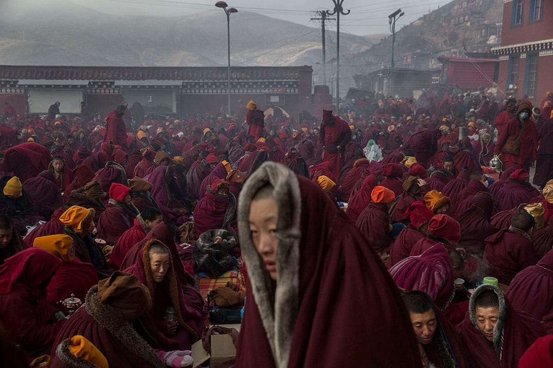 天氣寒冷，喇嘛們披著厚厚的上衣，在佛學院裡坐著。攝：Kevin Frayer/Getty Images