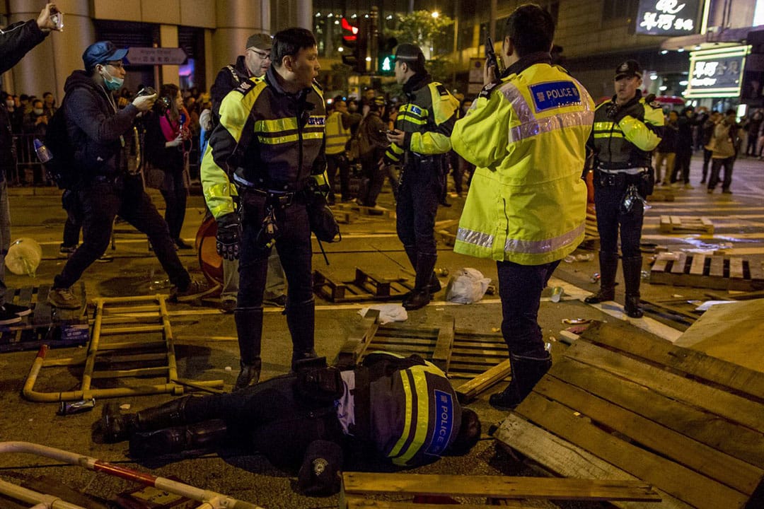 2016年2月9日凌晨二時，旺角，一名警察在亞皆老街倒地。攝：Billy H.C. Kwok/端傳媒