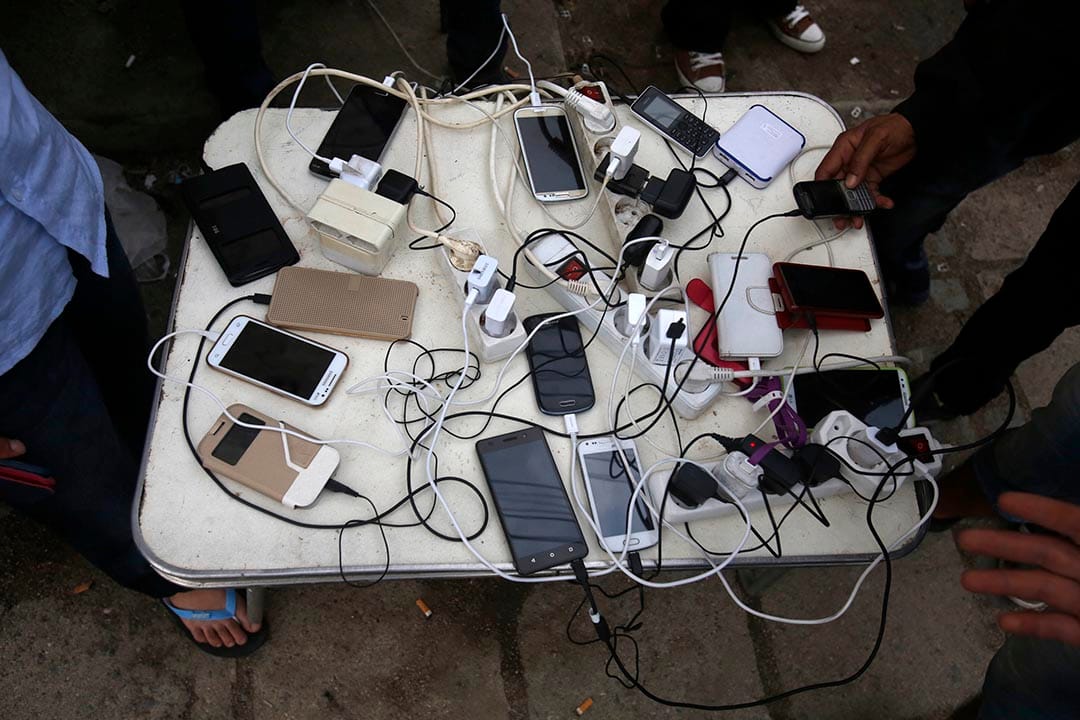 2015年8月22日 馬其頓蓋夫蓋利亞 難民為他們的電話充電。攝: Darko Vojinovic /AP