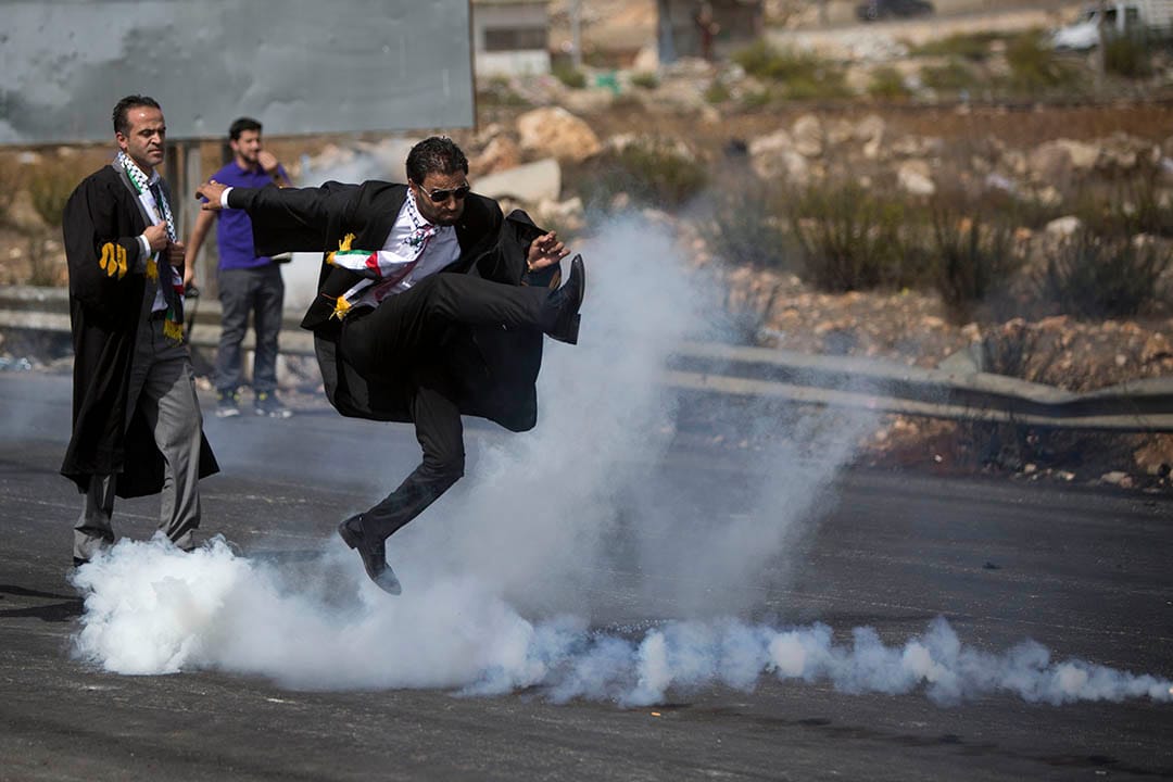 2015年10月12日，巴勒斯坦拉姆安拉，  一名律師在律師公會發起的遊行中腳踢催淚彈罐。攝：Majdi Mohammed/AP