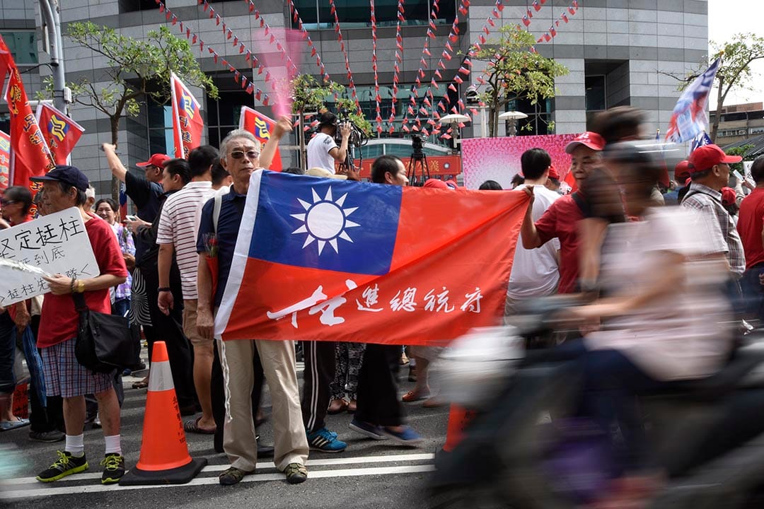 一名支持洪秀柱的民眾在國民黨中央黨部外拿著支持洪秀柱的旗幟。攝 : 陳弘岱/端傳媒 