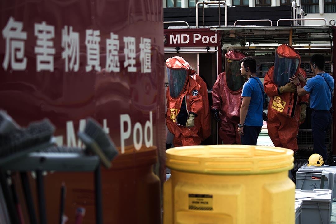 2015年8月21日，消防人員配戴裝備及穿上化學保護袍準備進行危害物質洩漏事故演習。攝：盧翊銘/端傳媒