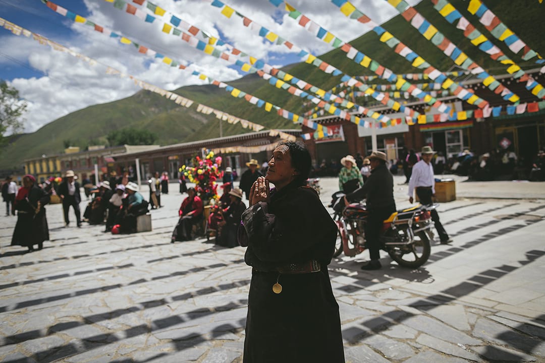 一名到藏族信徒在新寨嘉那嘛呢石堆祈福许愿。摄 : 王嘉豪/端传媒