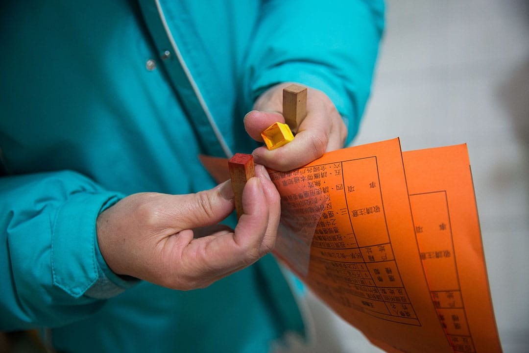 投票當天，謝素嬉拿著印章與通知單到投票站。攝:Billy H.C. Kwok/端傳媒  