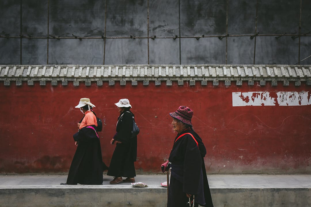 几位藏族群众从新寨嘉那嘛呢石堆附近走过。摄 : 王嘉豪/端传媒