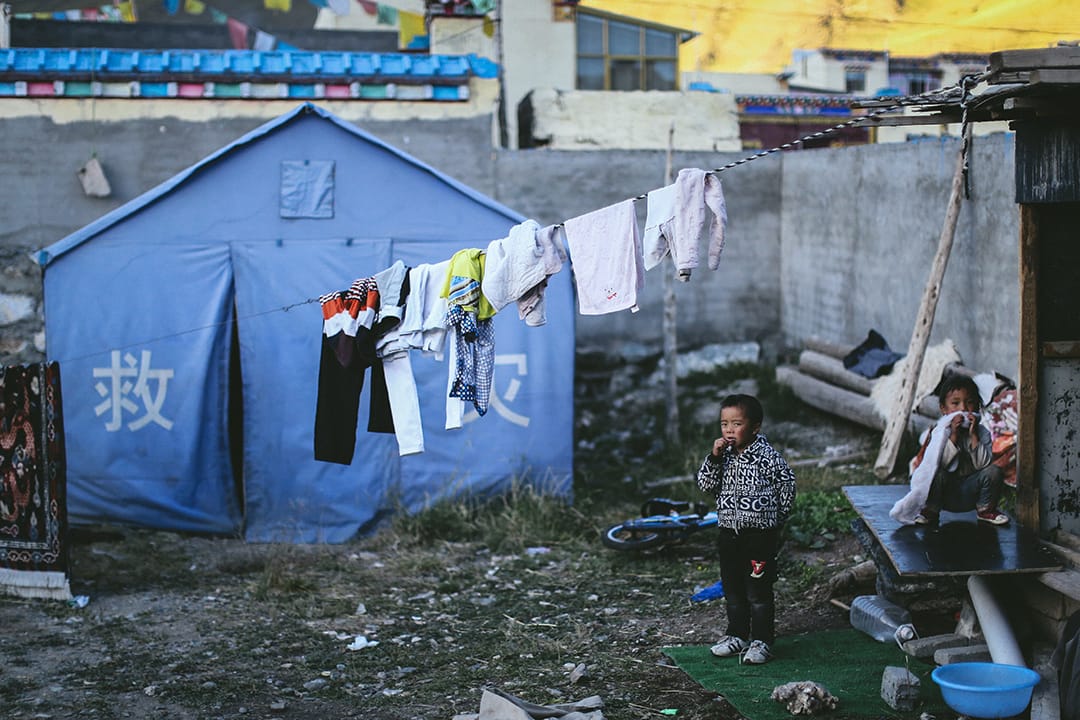 移民村内仍摆放了救灾用的帐篷。摄 : 王嘉豪/端传媒