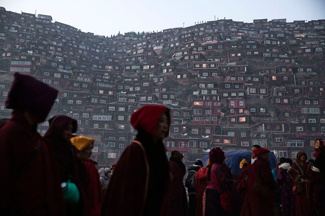 喇嘛和覺姆們離開佛學院，沿著黑暗的路回家。攝：Kevin Frayer/Getty Images