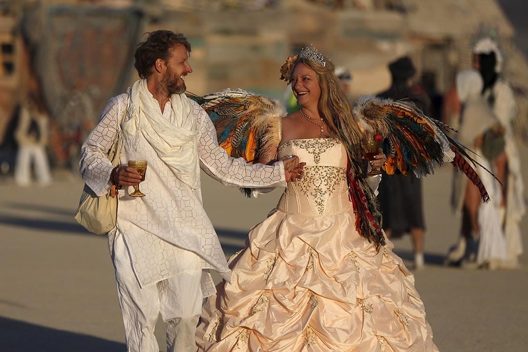 日出时分，有参加者穿上盛装，于沙漠上行走。摄：Jim Urquhart/Reuters