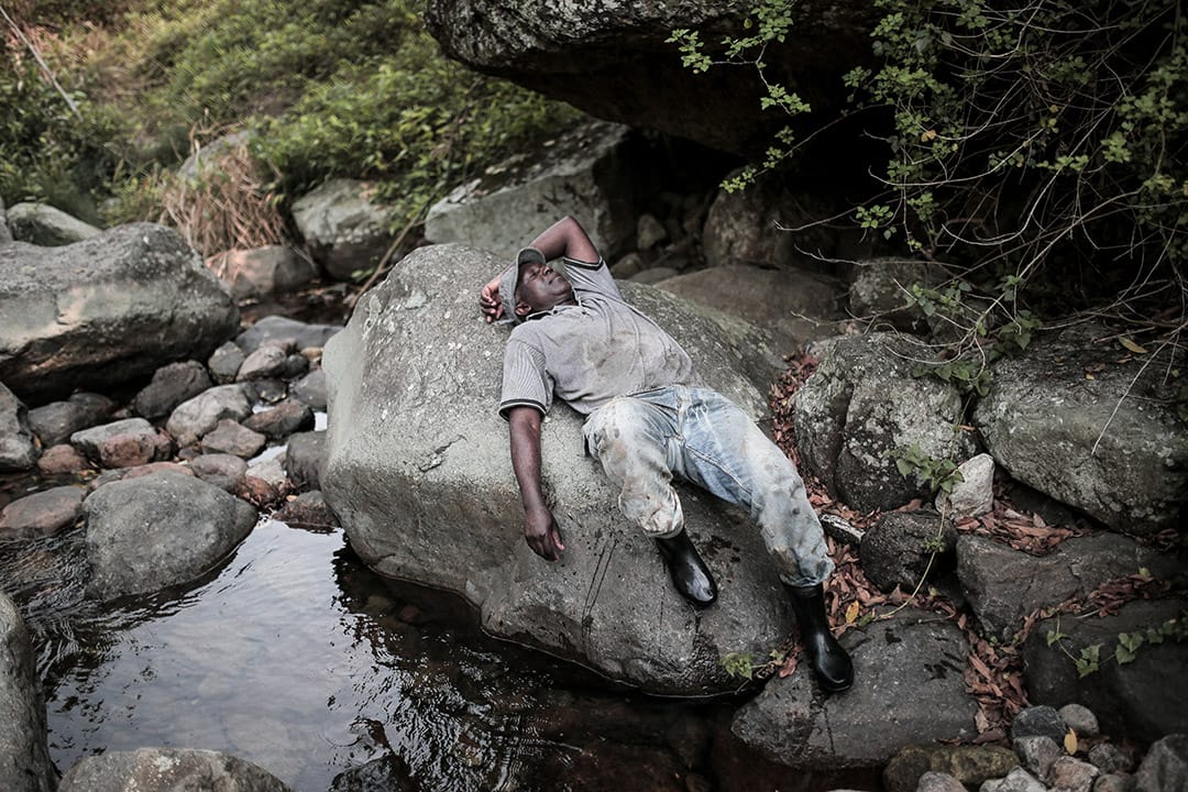 一位难民于大石上休息。摄: Billy H.C. Kwok/ 端传媒