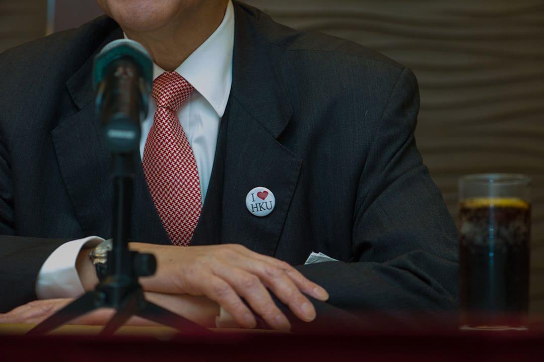 2016年1月28日，香港大学校委会主席李国章召开记者会谴责有学生在早前的校委会结束后包围他，席间他戴上“我爱港大”襟章。摄：叶家豪/端传媒