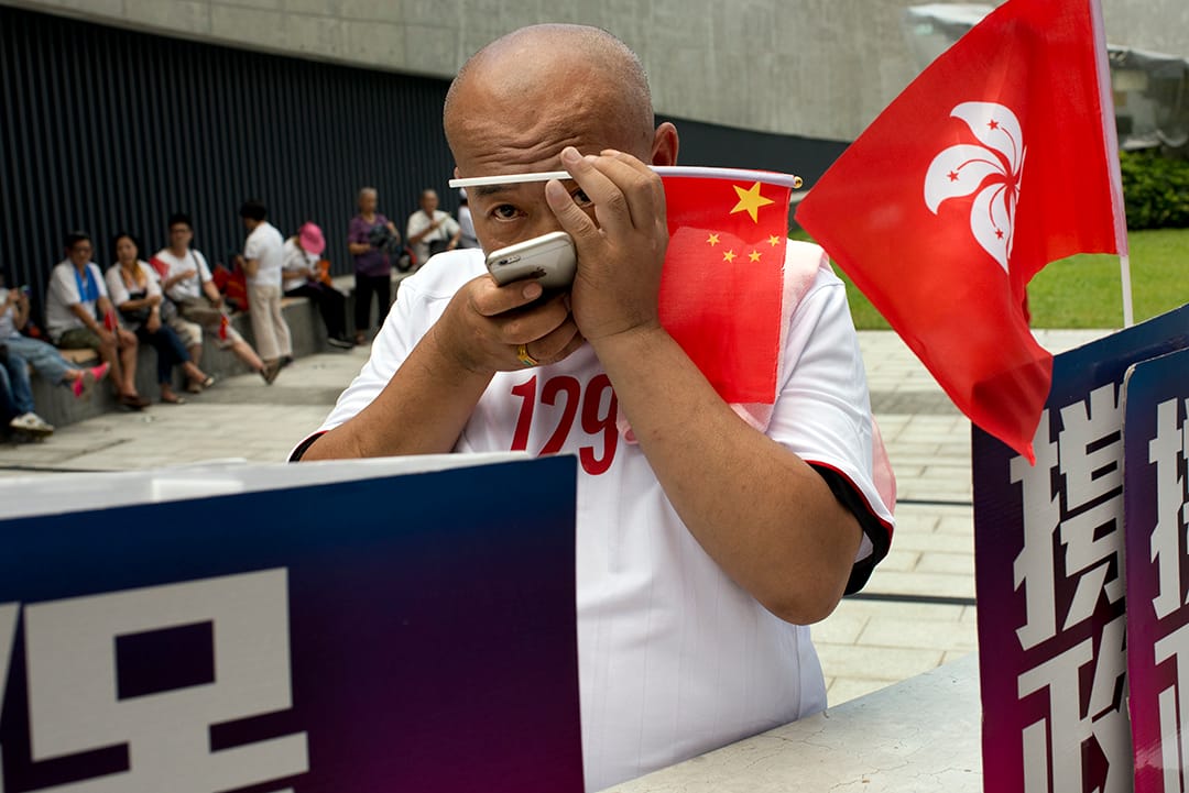 支持政改人士手持中國國旗，於今年6月政改表決當日在立法會外集會。攝:Eric Rechsteiner-Panos/端傳媒