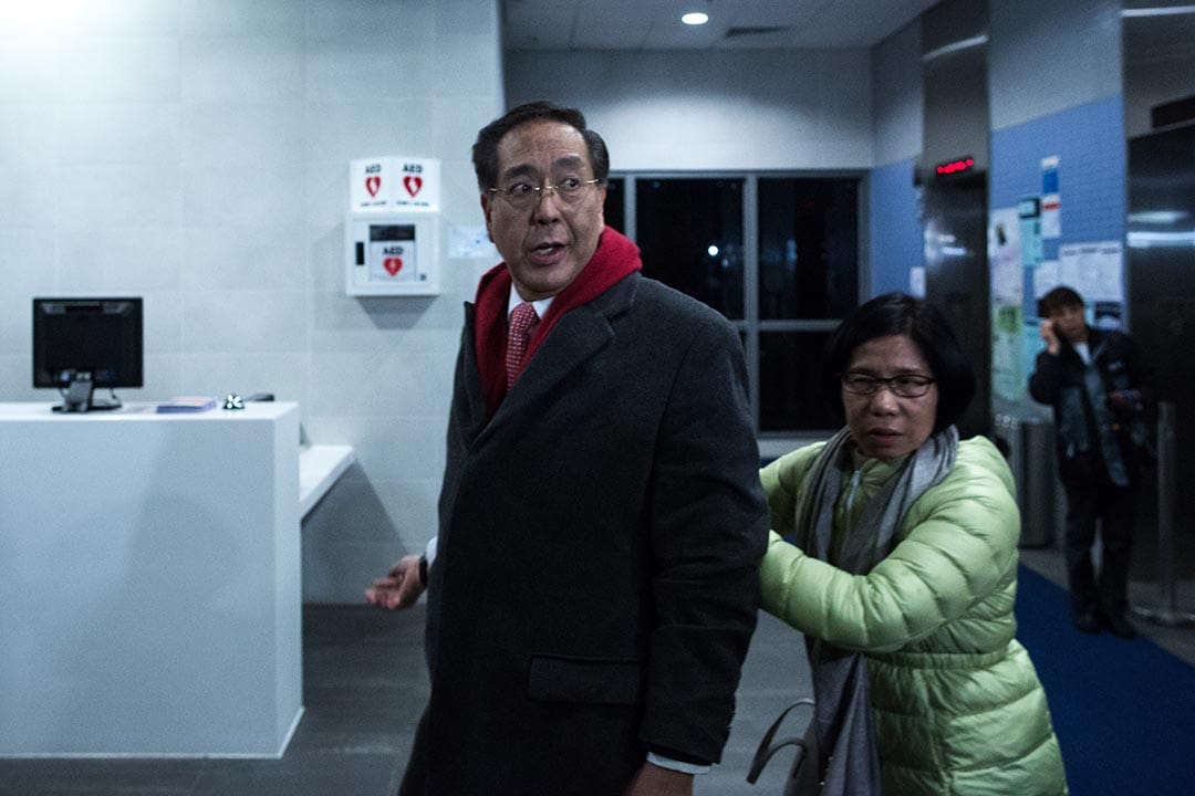 2016年1月26日，李国章首次主持港大校委会议后，于大楼外遇见大批示威学生需要退回大楼内暂避。摄：卢翊铭/端传媒