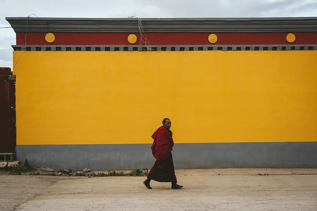 一名喇嘛在治多县街道上走过。摄 : 王嘉豪/端传媒