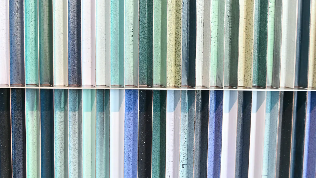 Abstract image of vertical colorful stripes with shades of blue, green, and gray. The textured surfaces create a harmonious and calming pattern.