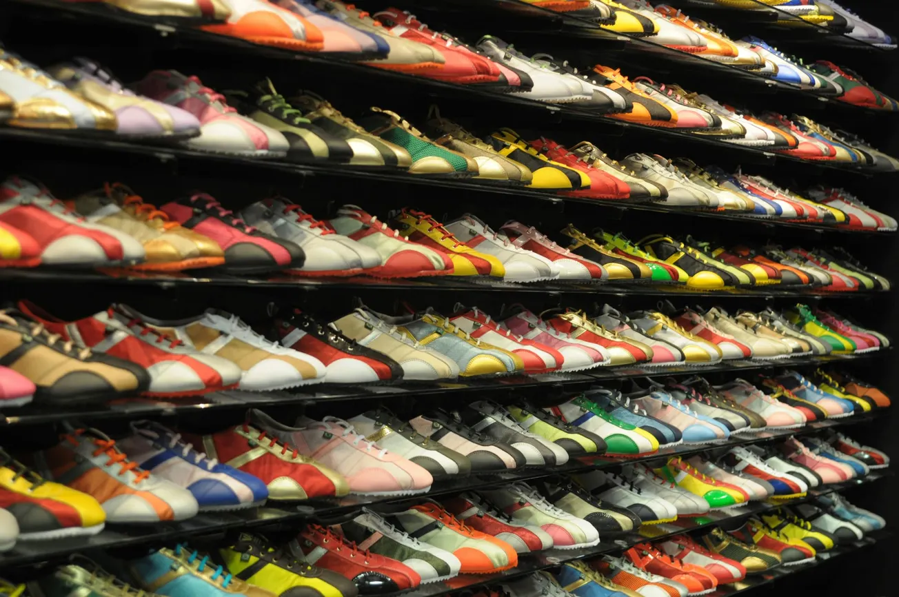 Rows of colorful sneakers displayed on shelves, each pair featuring unique color combinations and designs, creating a vibrant and dynamic atmosphere.