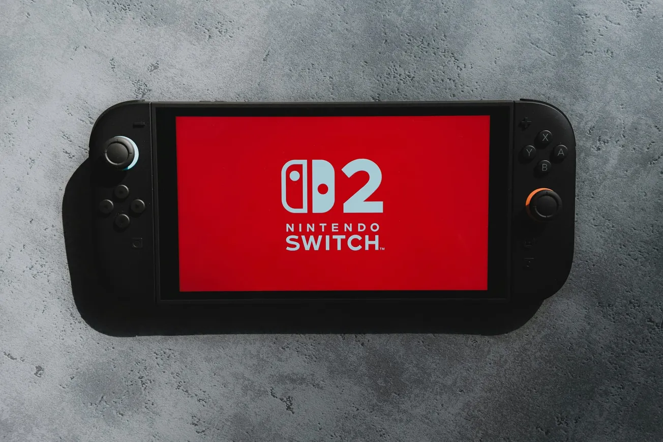 A Nintendo Switch Lite with a red screen displaying the text "Nintendo Switch" and "D2" in bold white letters, set against a gray textured background.