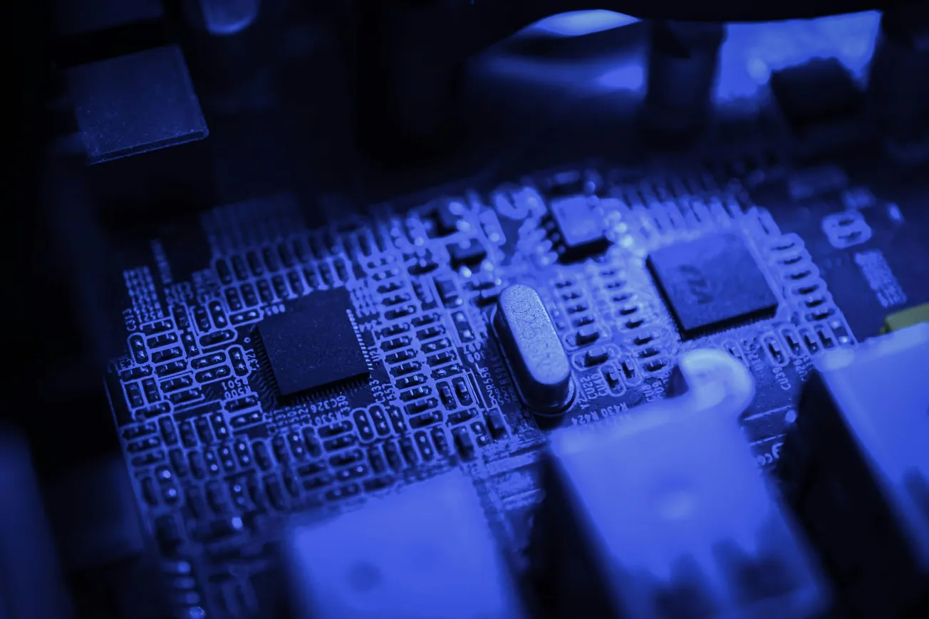 Close-up of a computer circuit board with various components in a blue-tinted light, emitting a futuristic, high-tech atmosphere.