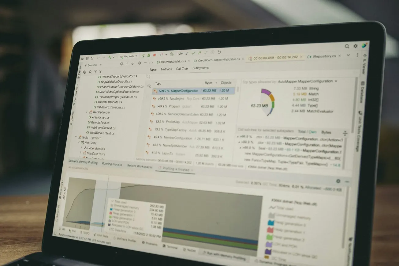Laptop screen displaying code analysis software with graphs and data charts. The image conveys a focused and tech-oriented atmosphere.