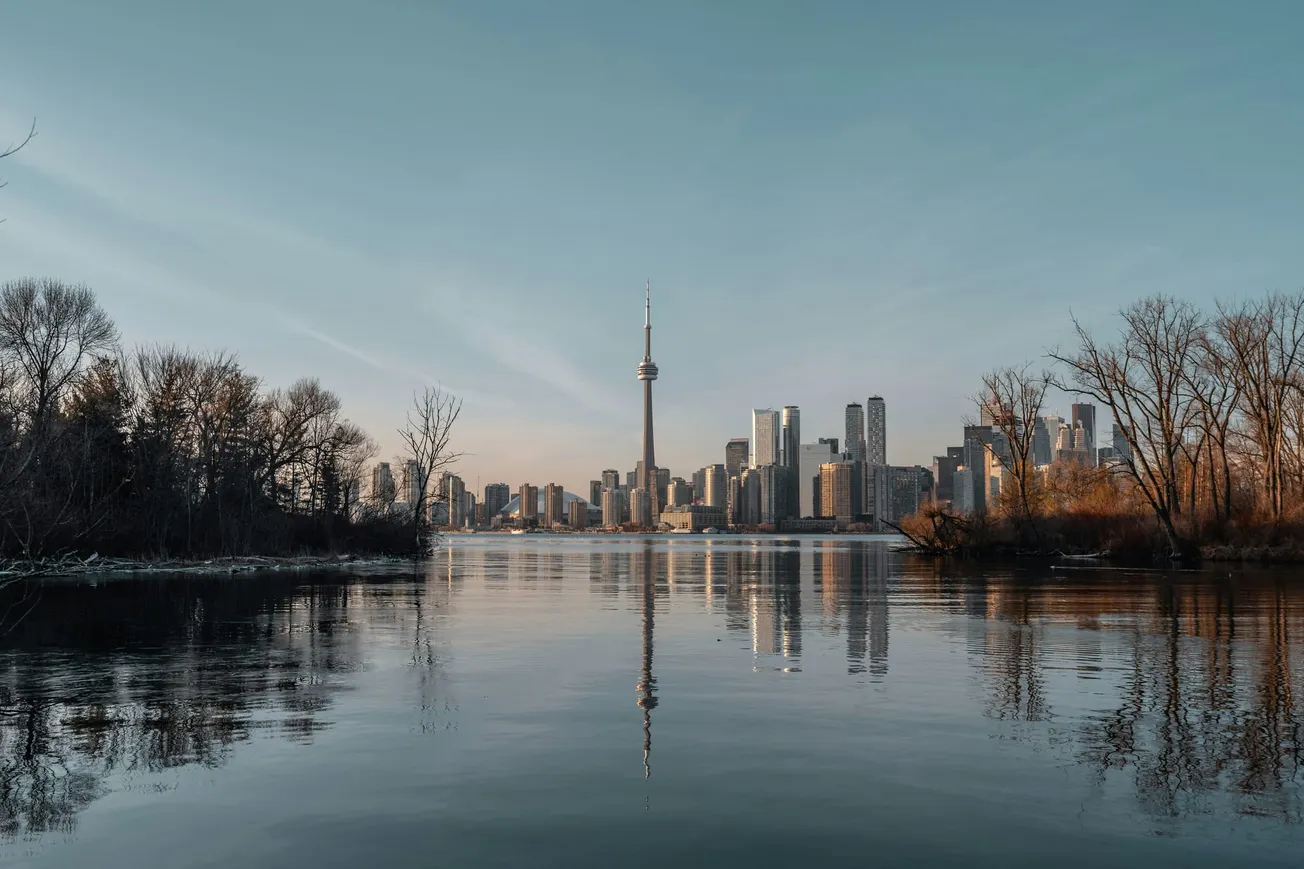 A scenic view of Toronto from the water, highlighting the city's skyline with its distinctive architecture and waterfront.