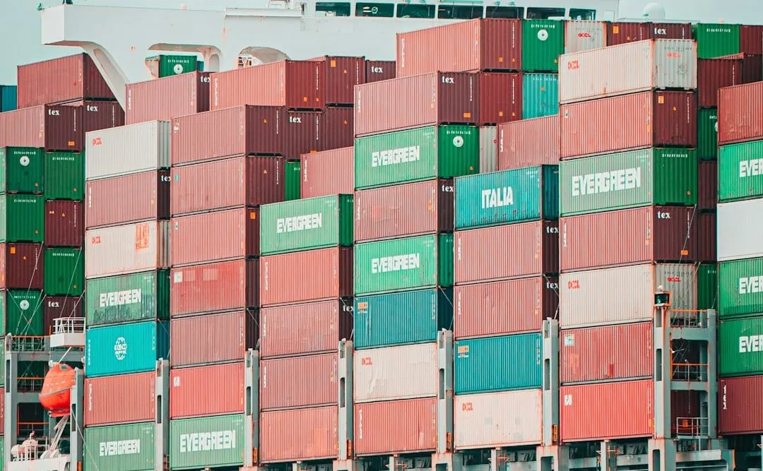 Global cargo ships navigate a busy port, symbolizing the complex flow of goods affected by changing international trade tariffs and supply chain regulations.