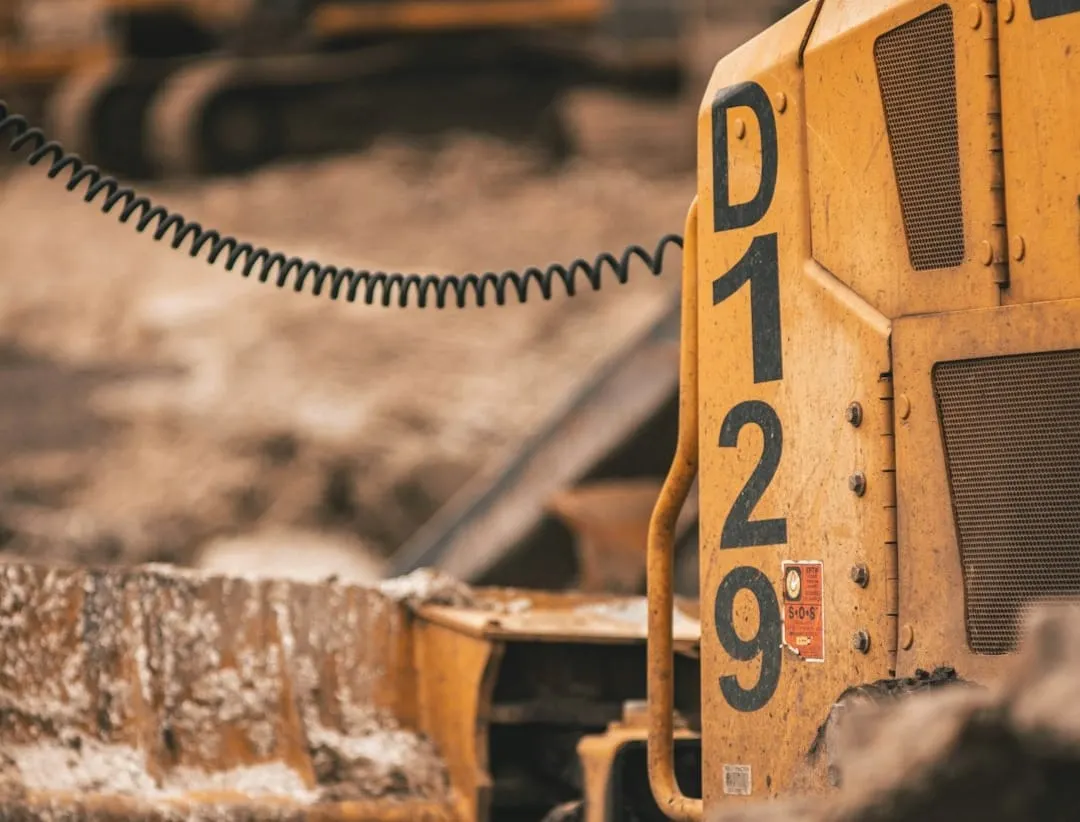 A modern excavator arm extends across a construction site, symbolizing strategic investment in heavy equipment for business expansion.