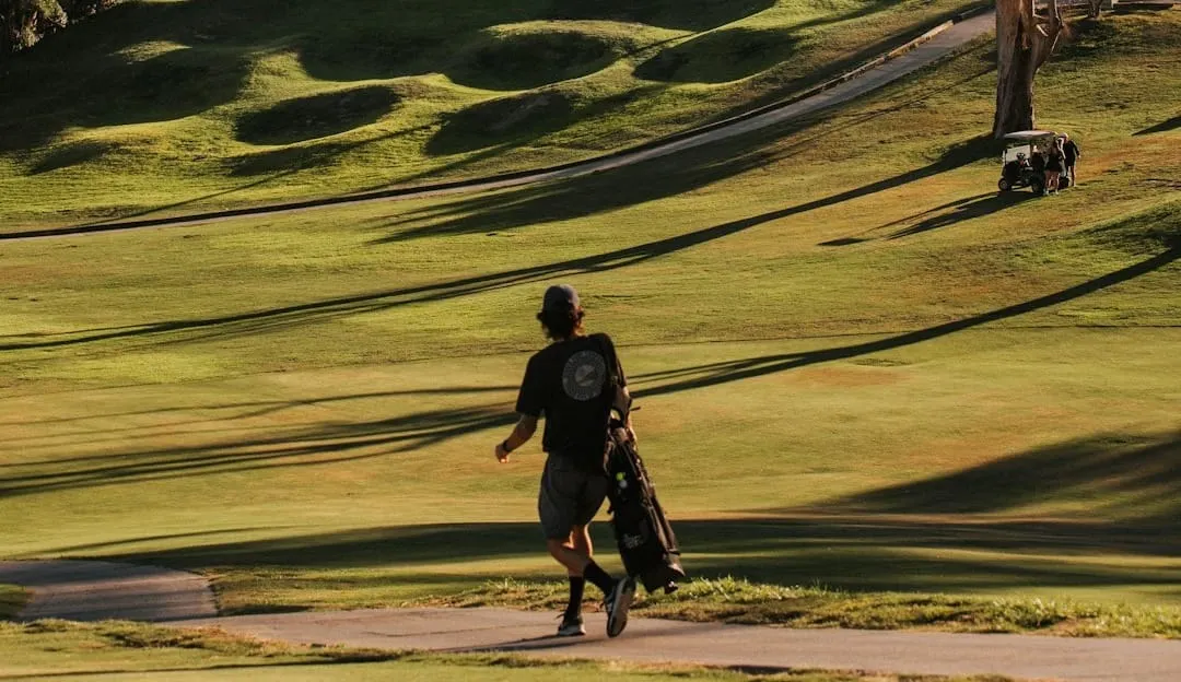 A person is actively using a smartphone to book a tee time online, showcasing the digital transformation of golf course operations and customer engagement.