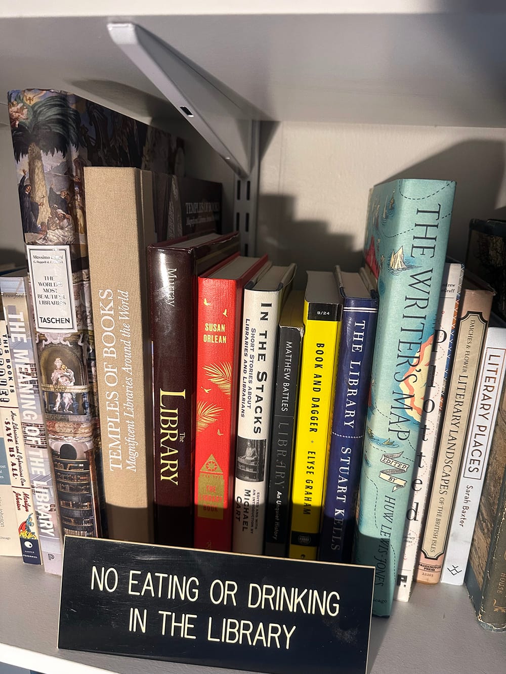 close up of black and white sign and a shelf of books