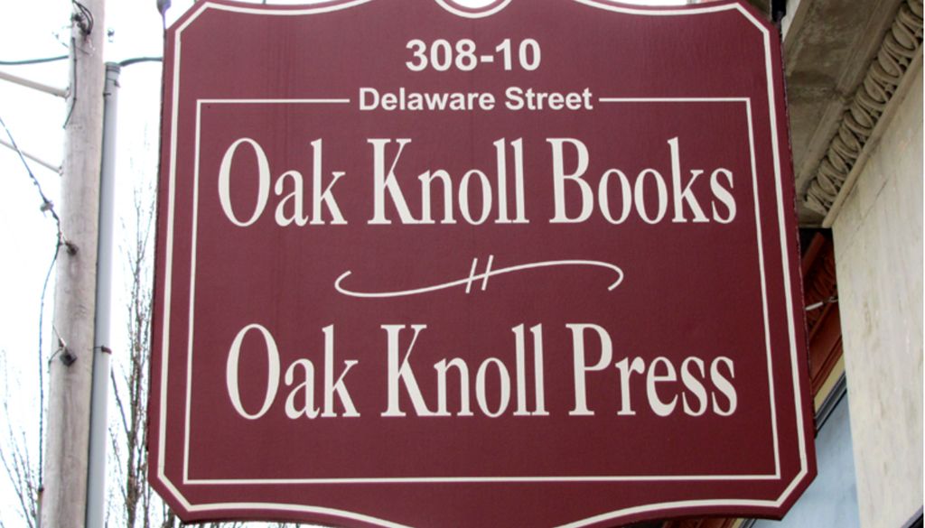 outdoor maroon street sign with white type on it for oak knoll book and press