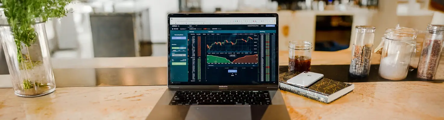 Laptop with a financial dashboard on a wooden table, representing ADHD-friendly budgeting tools and digital finance apps for easy money management.
