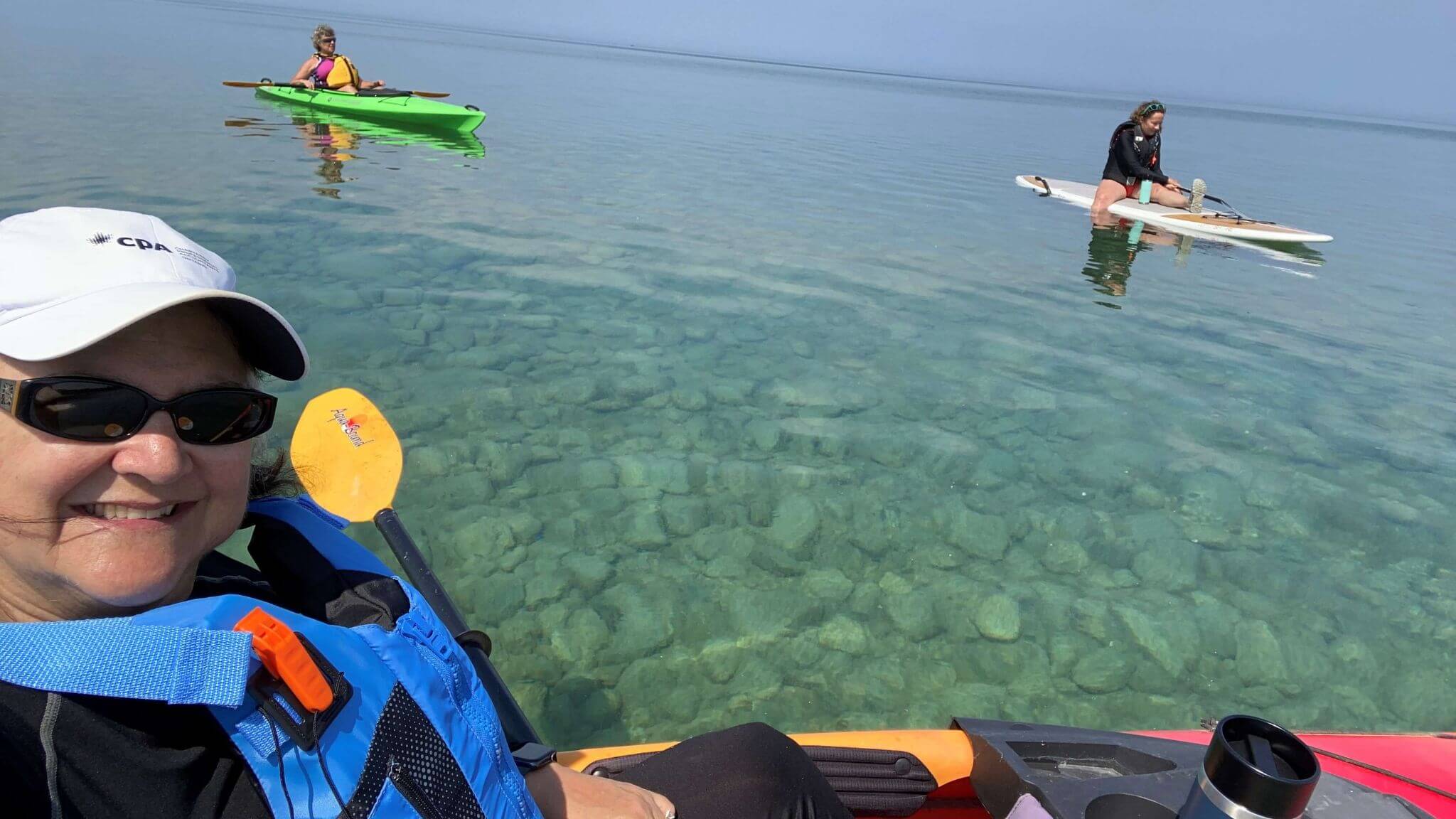 Deborah with friends kayaking and paddling, discussing which is harder?