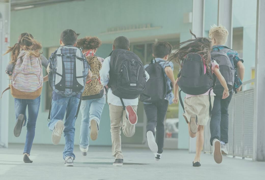 School boys with backpacks running to class
