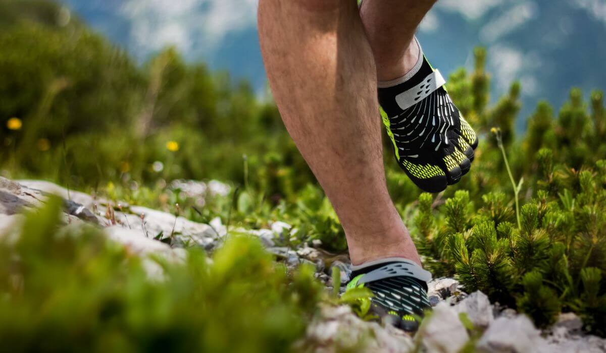 Runner on lakeside trail wearing barefoot running shoes.