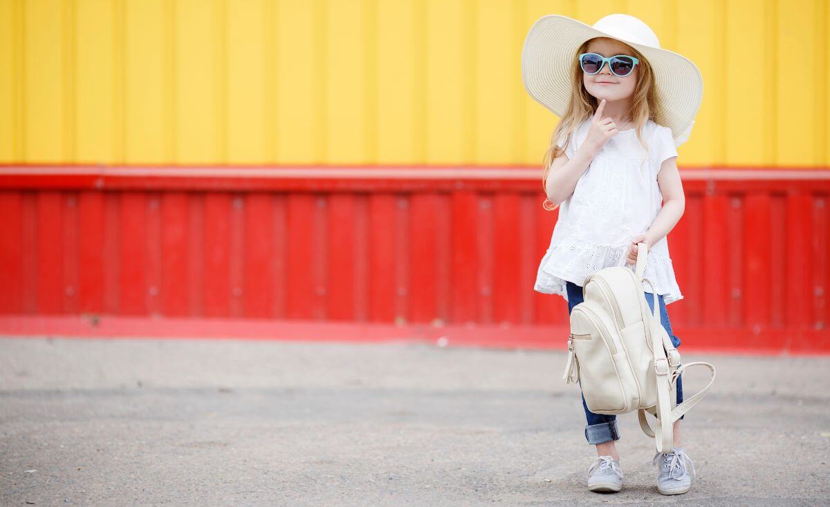 Cute young girl with white backpack.