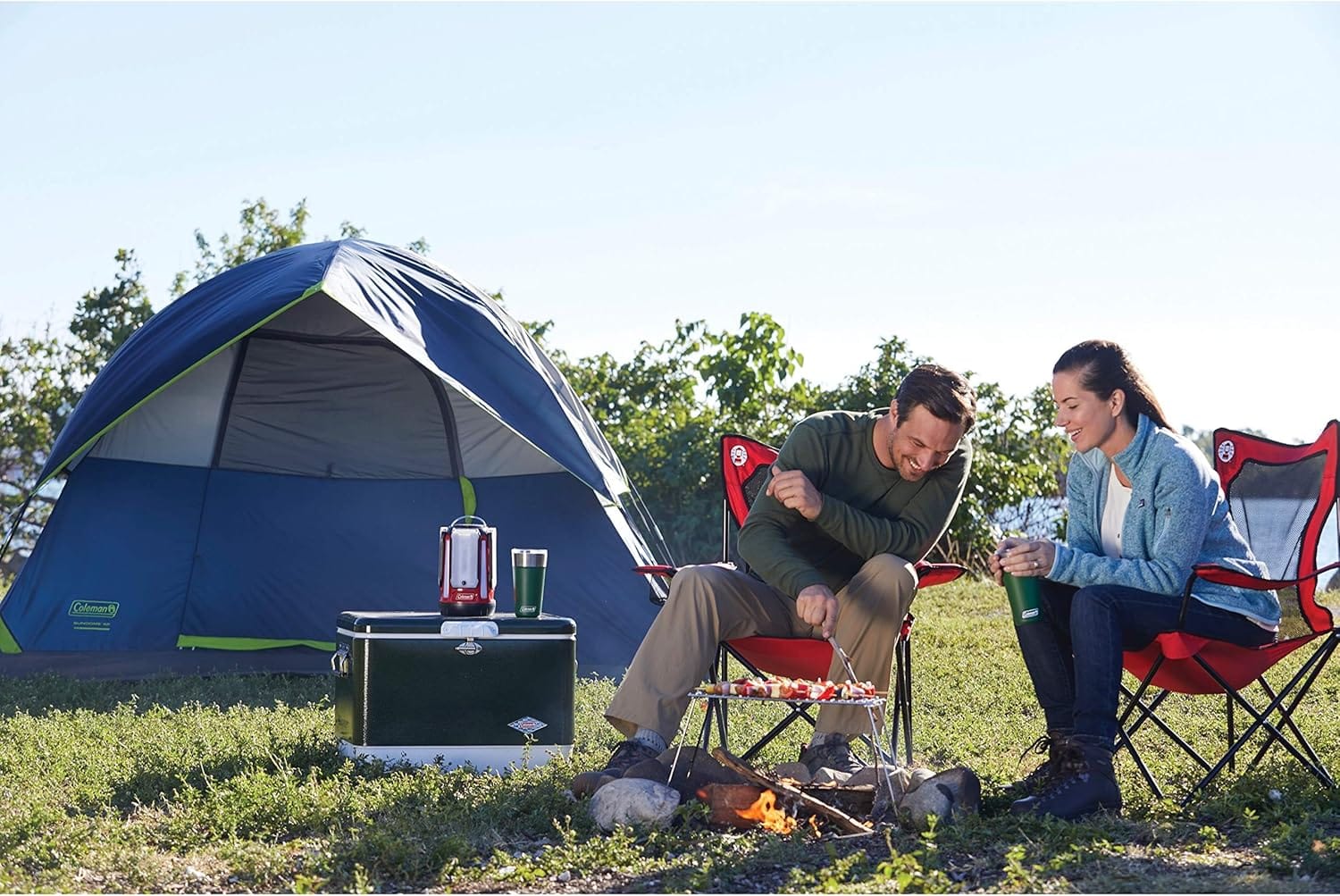 Coleman Sundown Tent with couple cooking dinner over fire