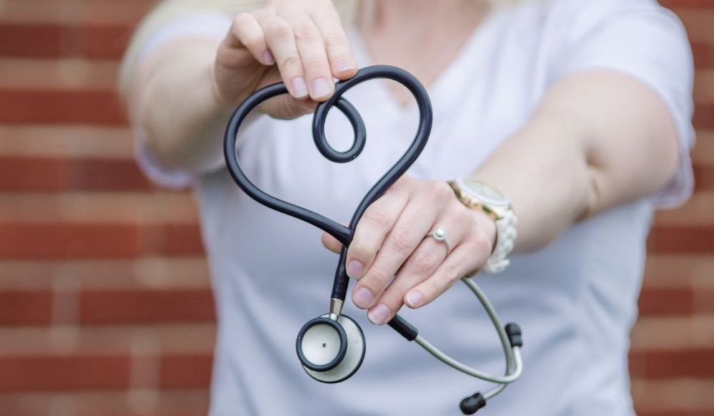 Nurse showing her stethoscope as a heart