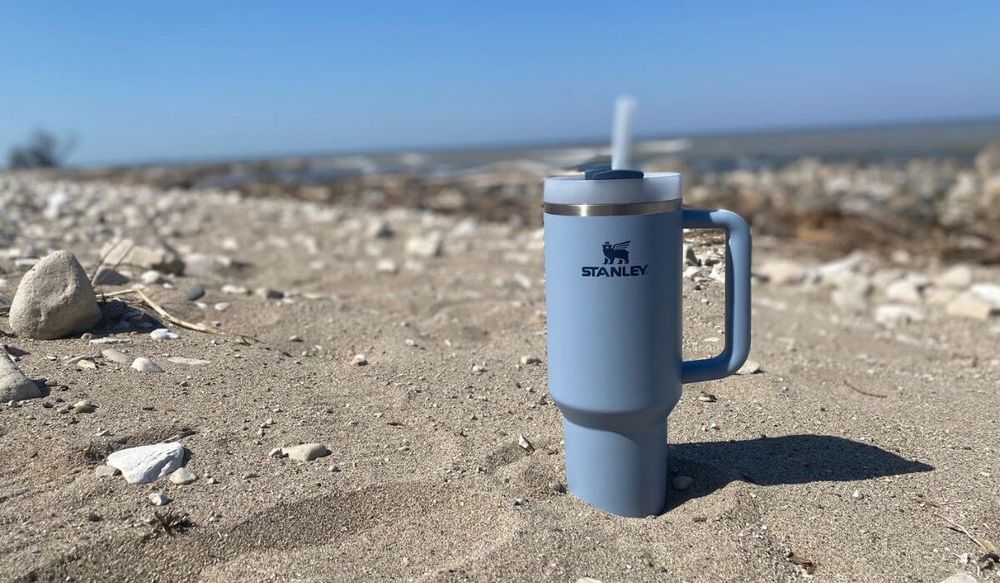 Blue Stanley Adventure Quencher in the sand at the lake