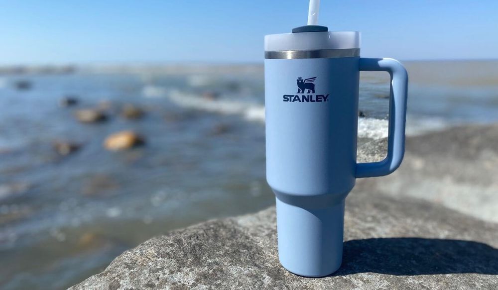 Stanley Quencher H2.0 FlowState Tumbler on a rock at the lake