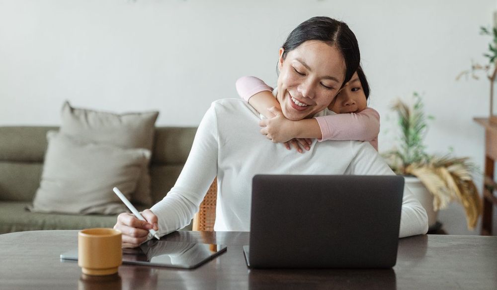 Work from Home No Phone | Daughter hugging mom while she works on laptop
