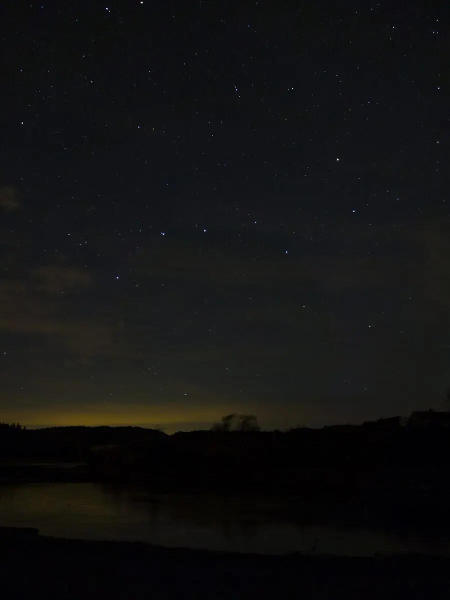 The Big Dipper asterism shining over a coastal night sky