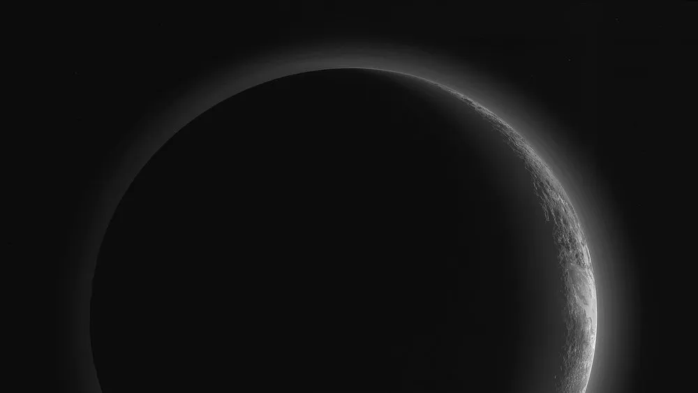 Pluto’s blue atmospheric haze, backlit by the Sun (New Horizons)
