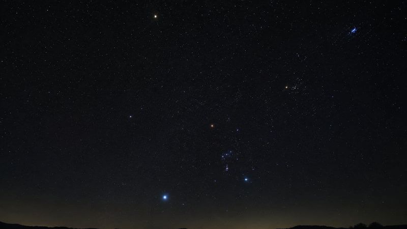 Orion rising over a dark horizon beside Sirius, Aldebaran and the Pleiades — bright stars whose names and meanings are centuries old