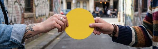 ShareCraft handing over practice knowledge as a yellow cardboard dot