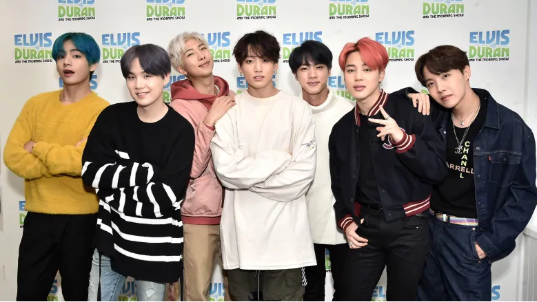 Integrantes de la banda BTS posando juntos en un evento de prensa, conocidos por su impacto global en la industria musical como líderes del K-pop.